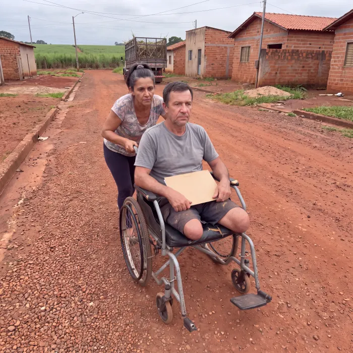 Valdir e uma mulher numa estrada de terra do povoado, com o canavial ao fundo